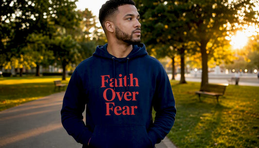 Man wearing navy hoodie with Faith Over Fear message