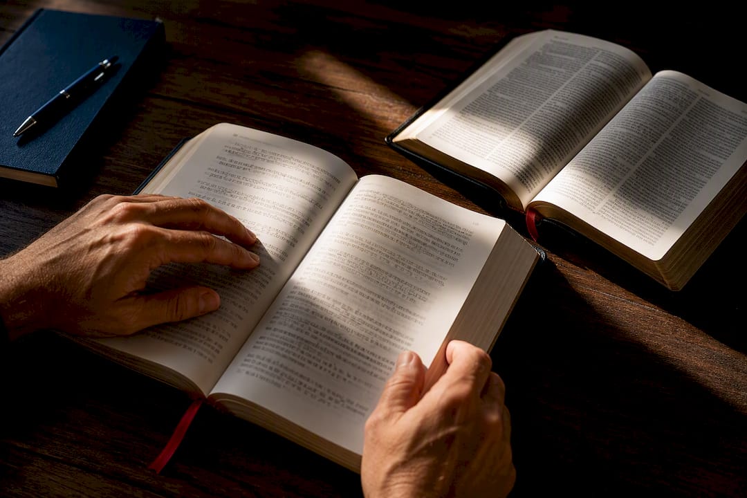 Hands studying Greek New Testament pages